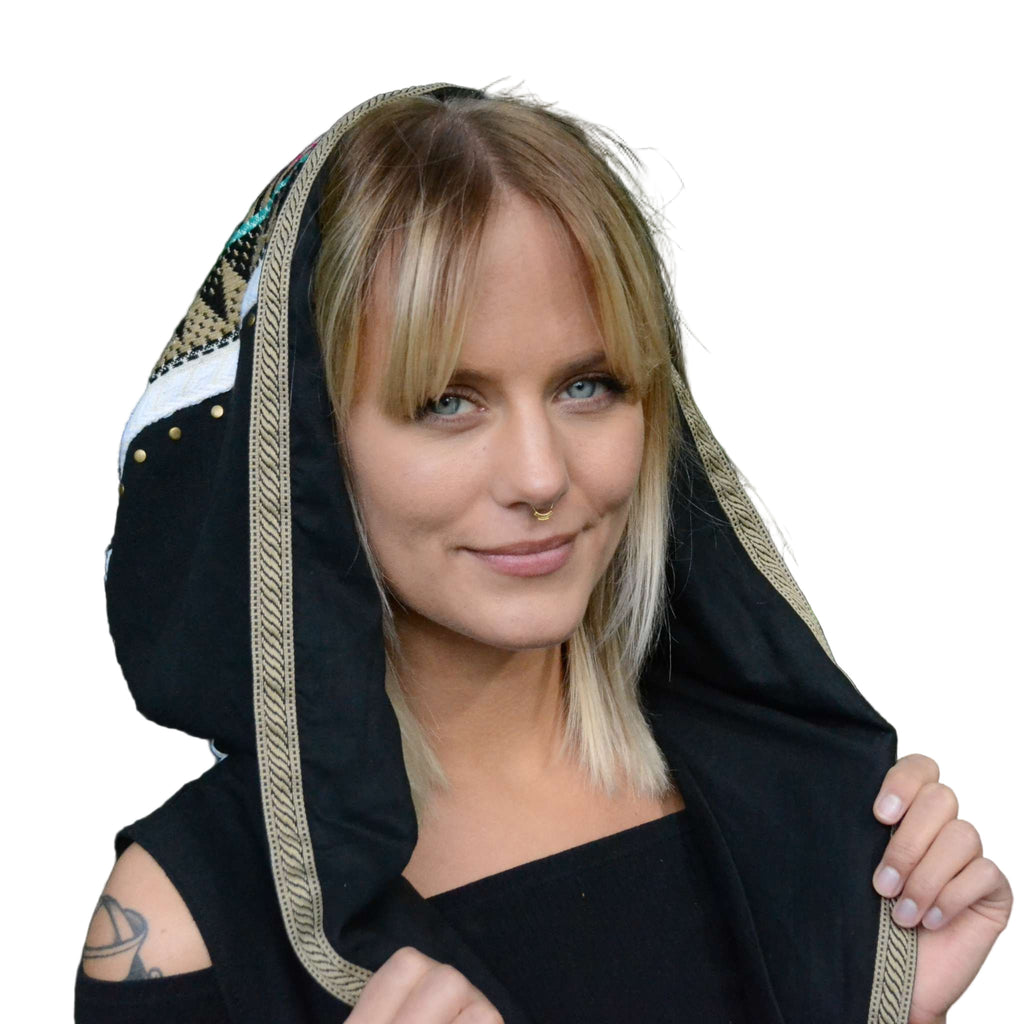 A person wearing a minimal fake septum gold adornment on her nose, featuring a tribal design with dotted details.