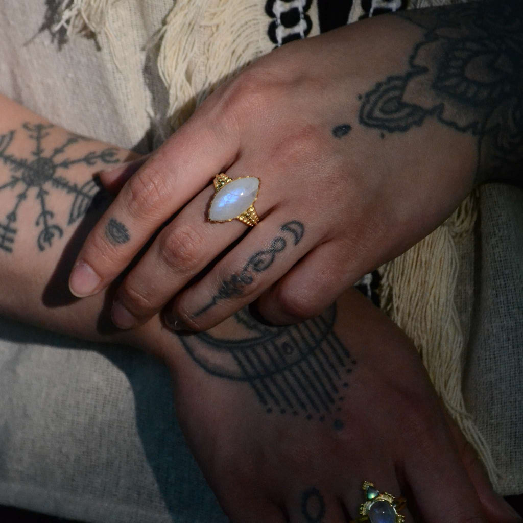 Bohemian brass ring with moonstone, worn on a hand.